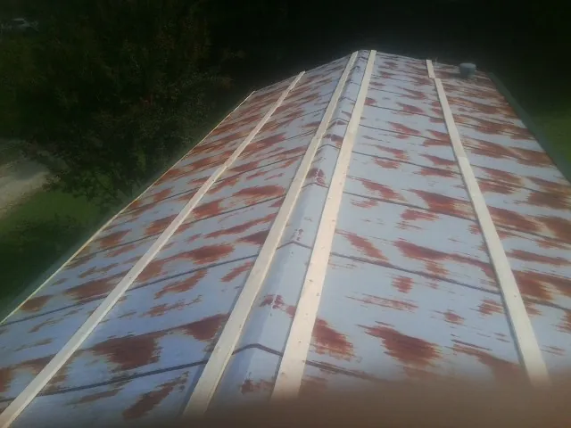 Rusted metal roof panels with new wood purlins before replacement — Storm Damage Roof Repair in Barberton by Roofing Brothers