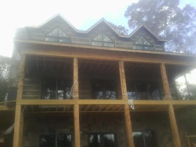 Dormers and porch framing on a large log home under construction — Roof Coating work by our crew in Barberton