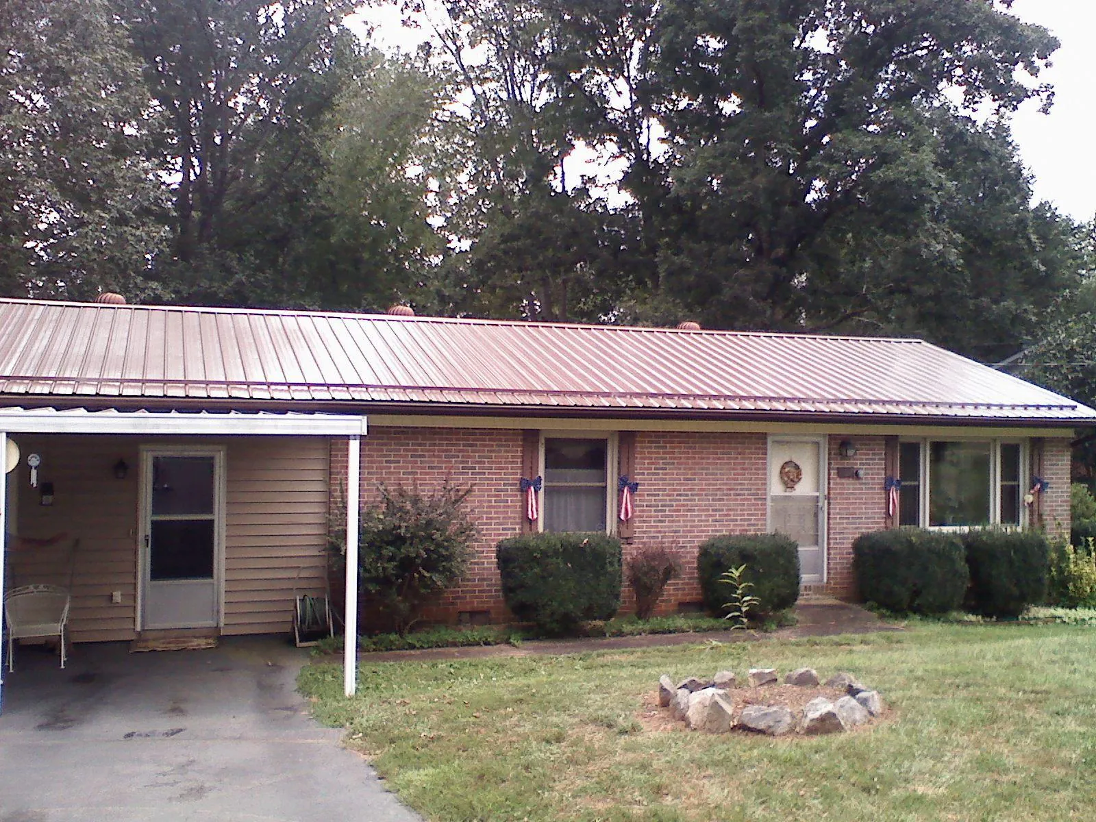 Bronze metal roof and carport on a brick ranch home — Roof Repair work by our crew in Barberton
